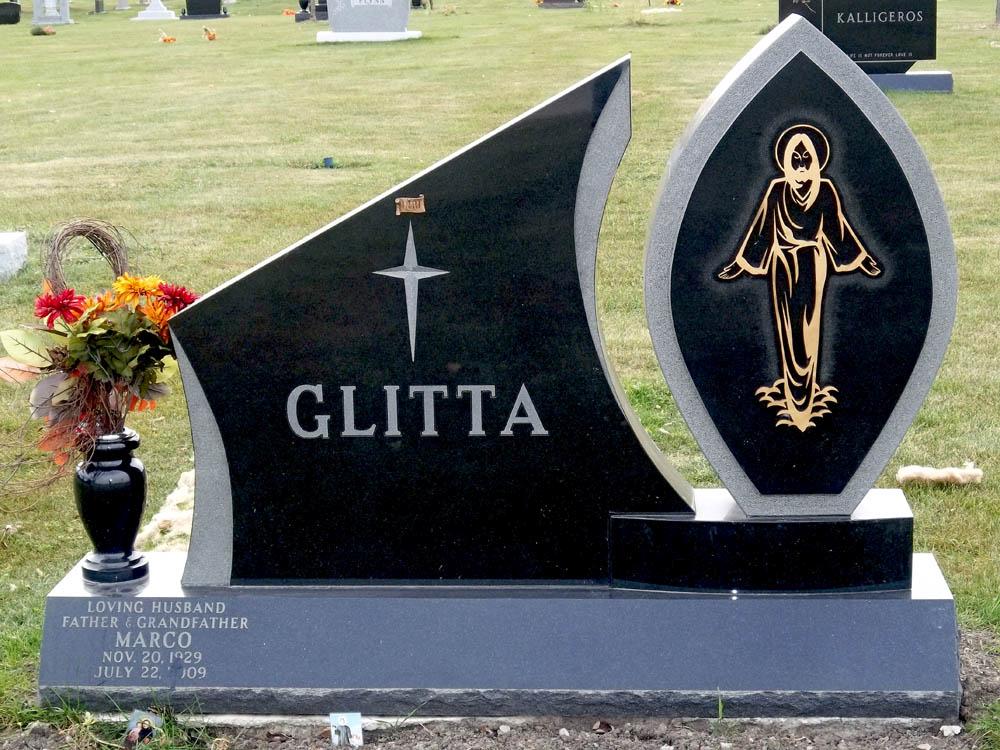 Family monument in black granite with an image of Jesus in bronze